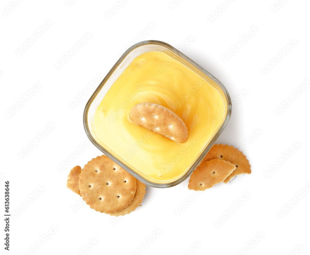 Bowl of tasty cheddar cheese sauce with crackers on white background