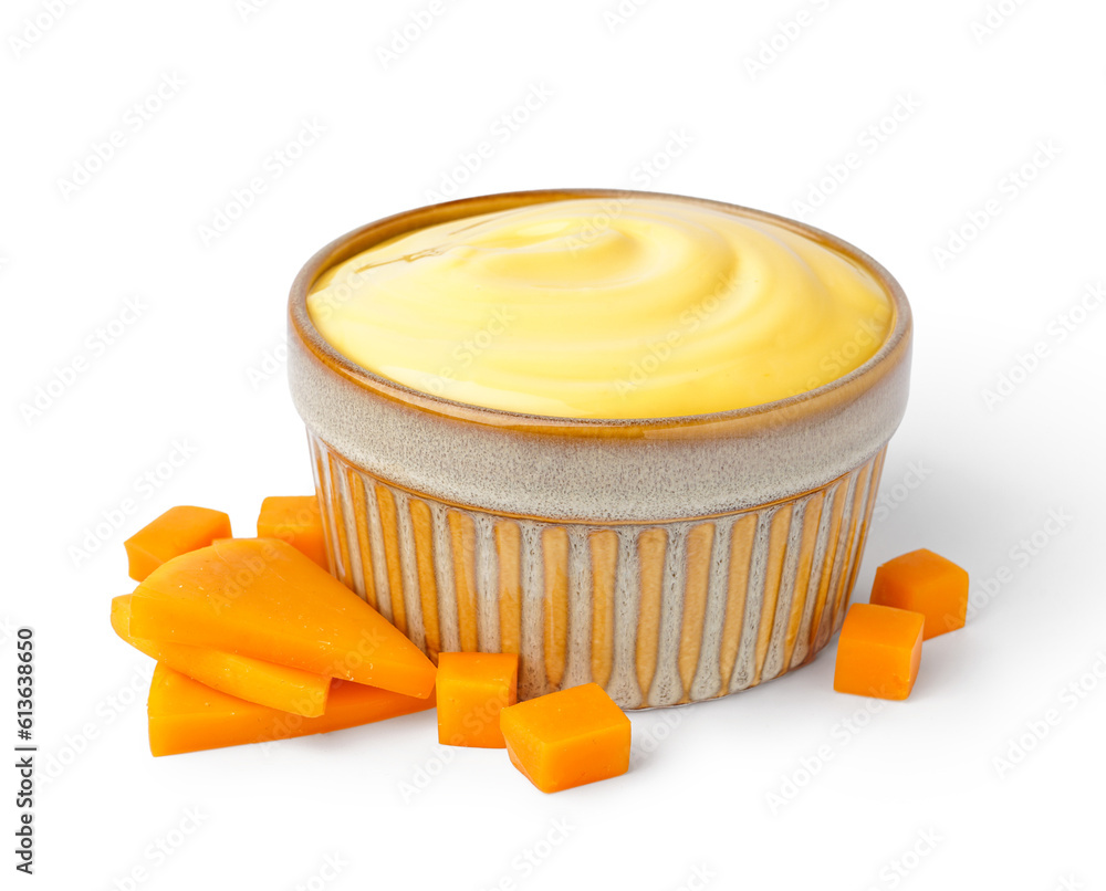 Bowl of tasty cheddar sauce with cheese slices on white background