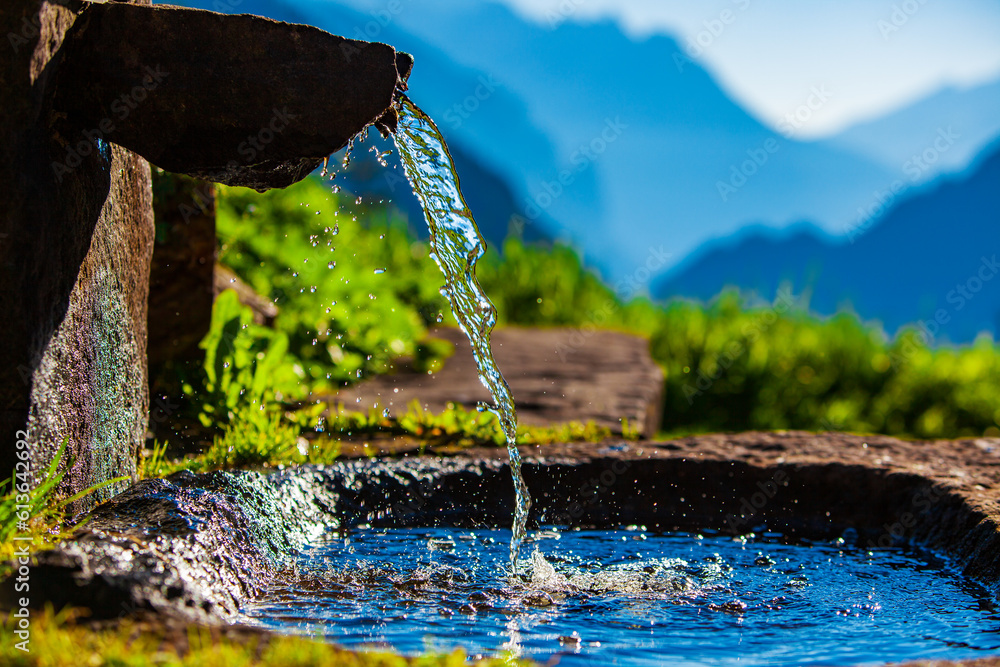 Water spring on Alps mountains background