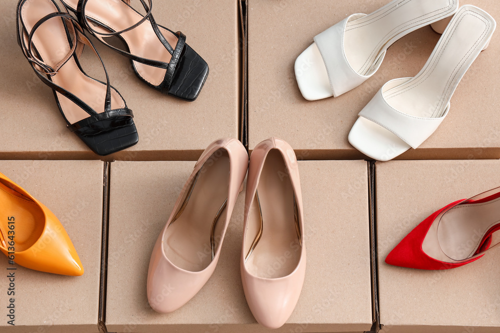 Cardboard boxes with high-heeled shoes on floor