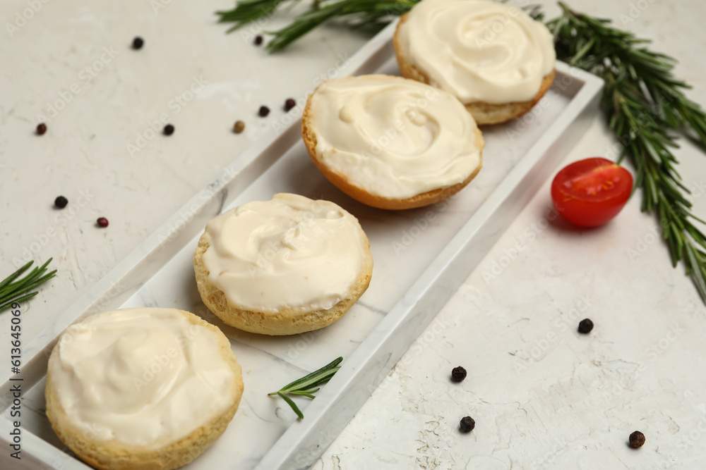 Plate of tasty croutons with cream cheese on light background