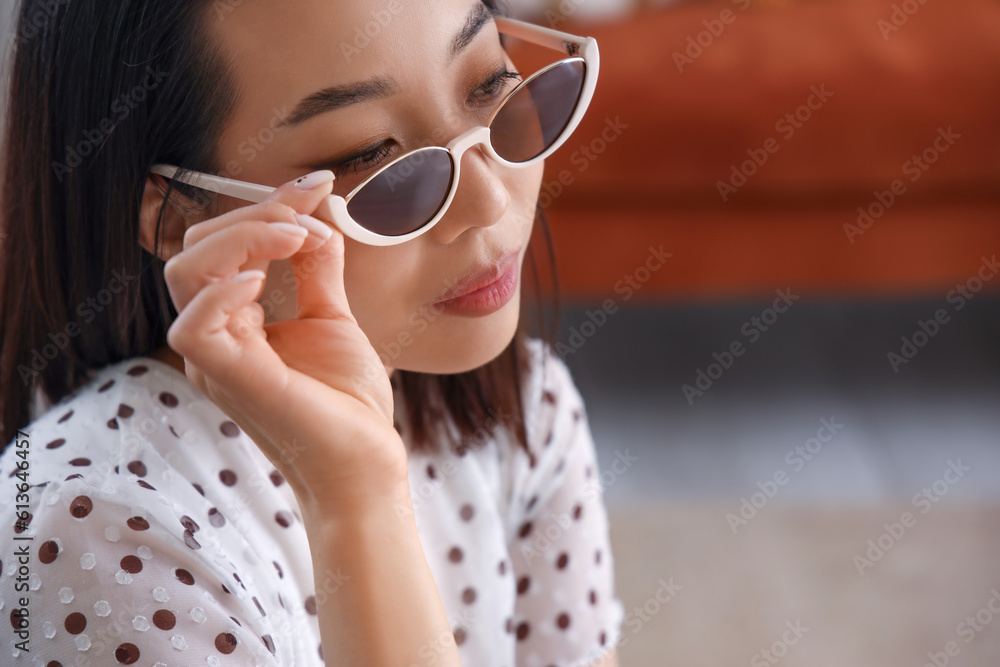 Beautiful Asian woman in stylish sunglasses at home, closeup