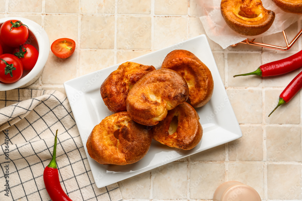 Plate with tasty Yorkshire pudding on light tile background