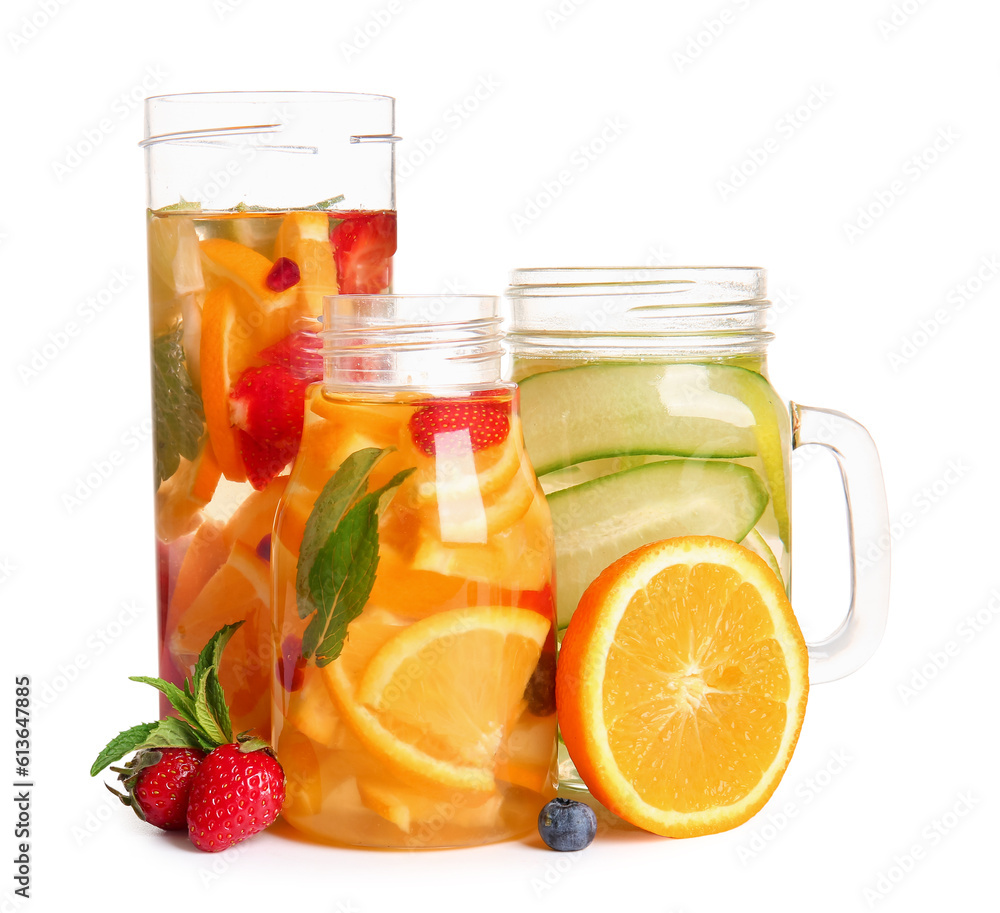 Bottles and mason jar of infused water with different sliced fruits on white background