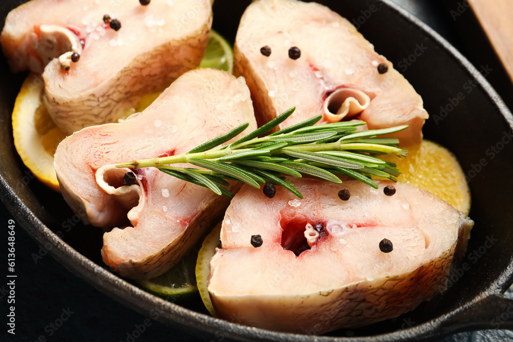 Baking dish with pieces of raw codfish on table, closeup