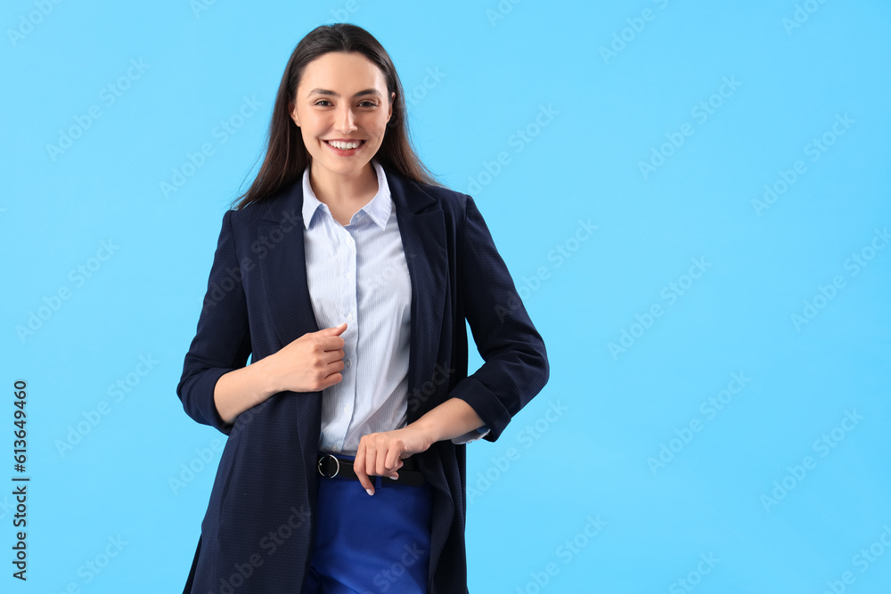 Young woman in stylish suit on blue background