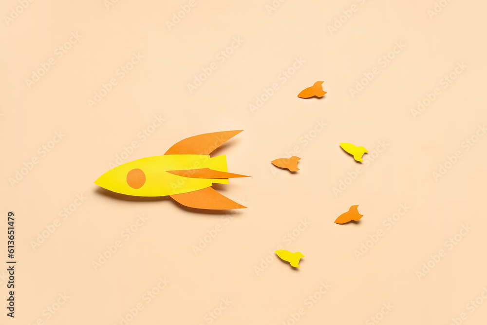 Paper color rockets on beige background