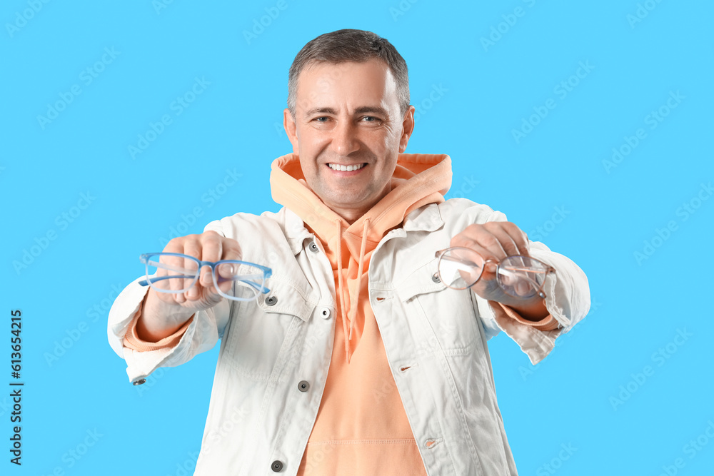 Mature man with eyeglasses on blue background