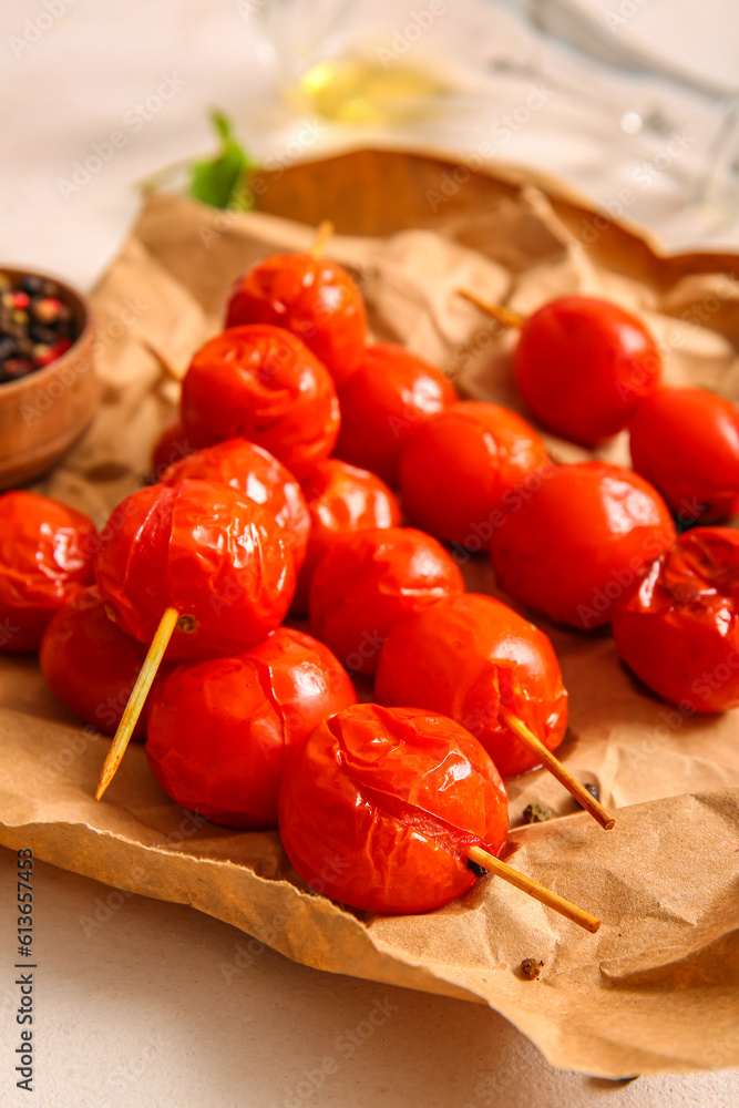 Baking paper and skewers with tasty grilled tomatoes, closeup