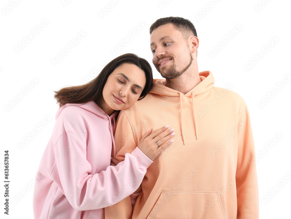 Happy engaged couple hugging on white background