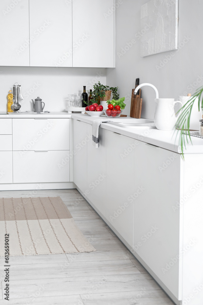 White countertop with sink and vegetables in modern kitchen