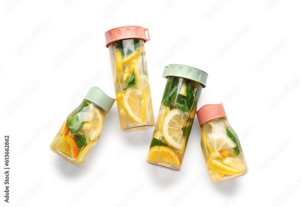 Sports bottles of infused water with lemon and mint on white background