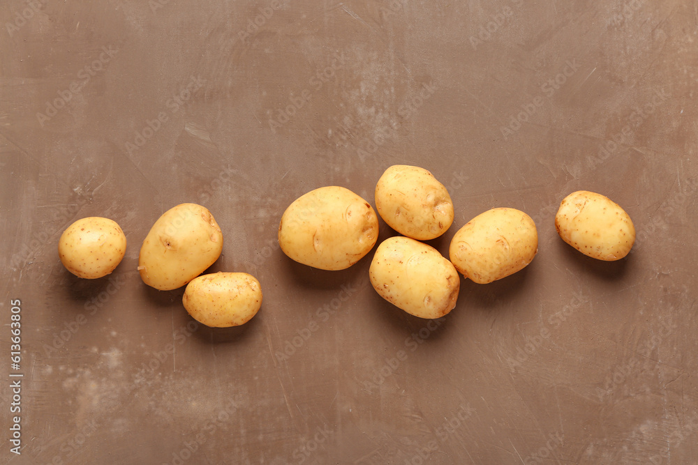 Raw baby potatoes on brown background