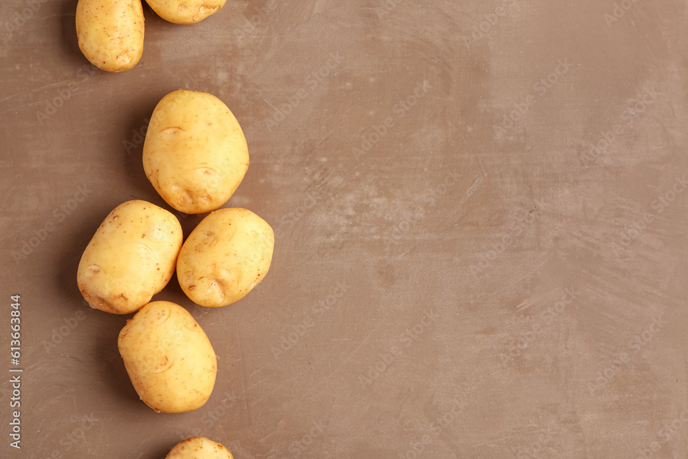 Raw baby potatoes on brown background