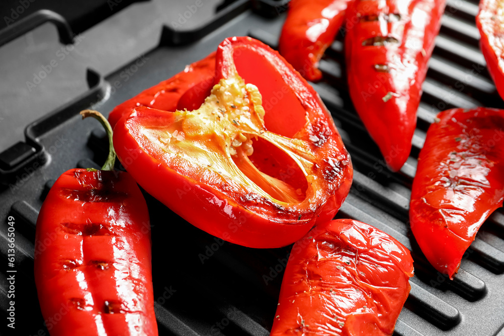 Grill with tasty peppers on table