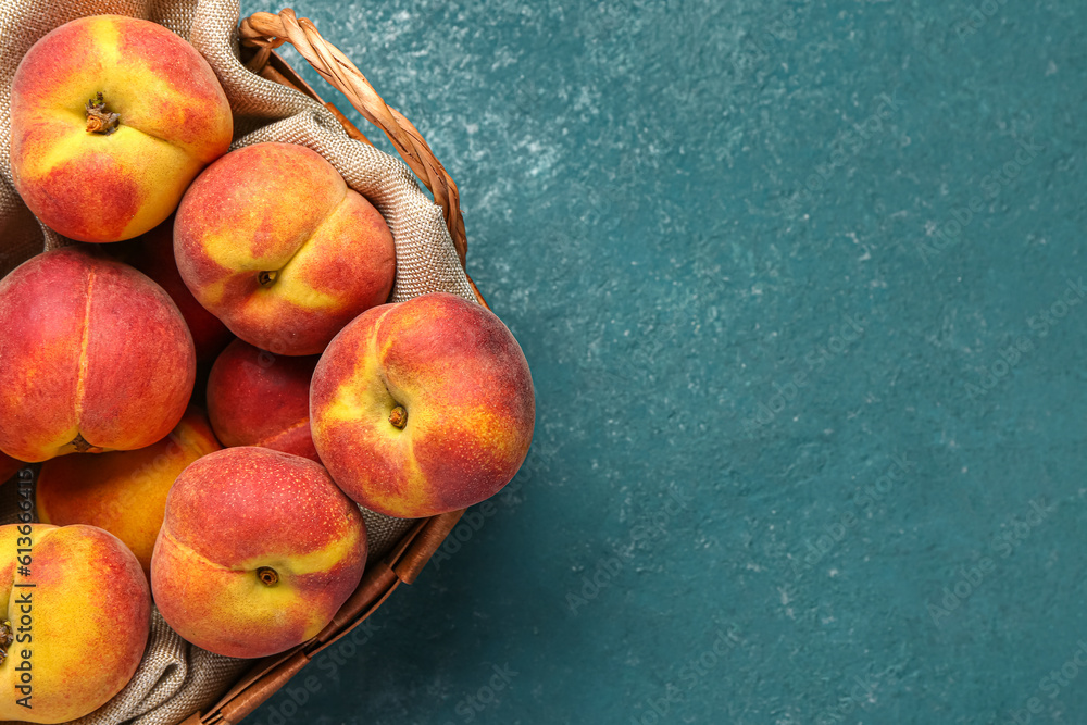 Wicker basket with sweet peaches on blue table