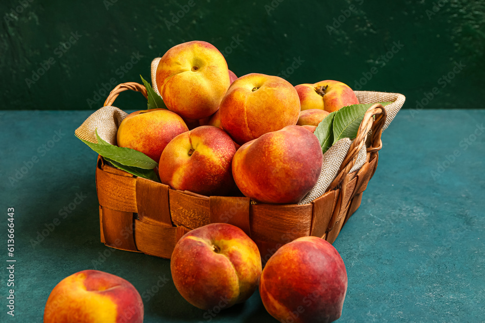 Wicker basket with sweet peaches on blue table