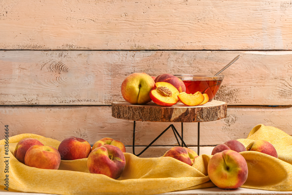 Board with sweet peaches on beige wooden background