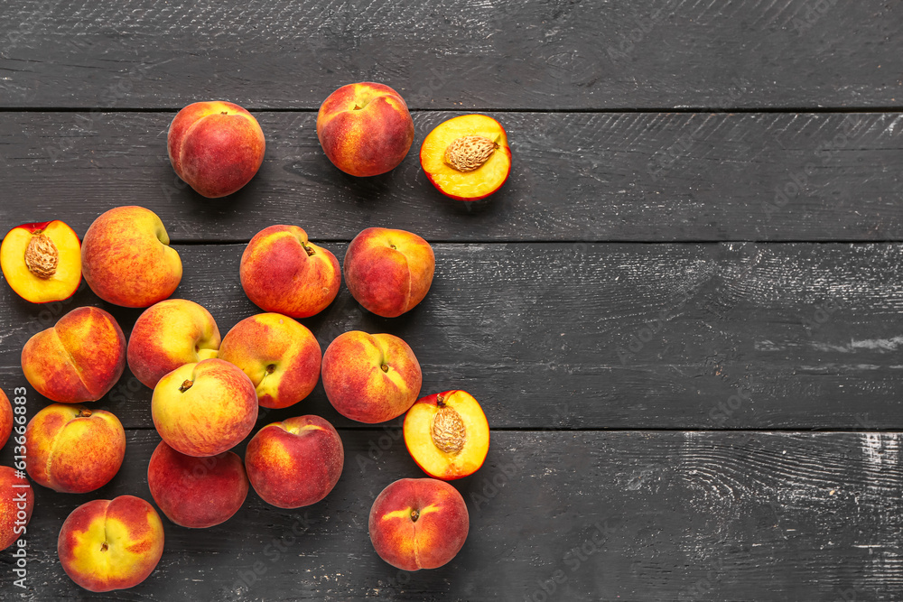 Many sweet peaches on black wooden background