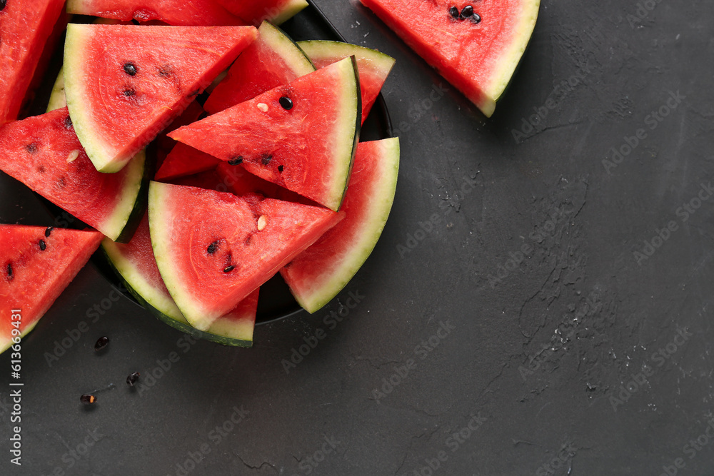 Tray with pieces of fresh watermelon on black background