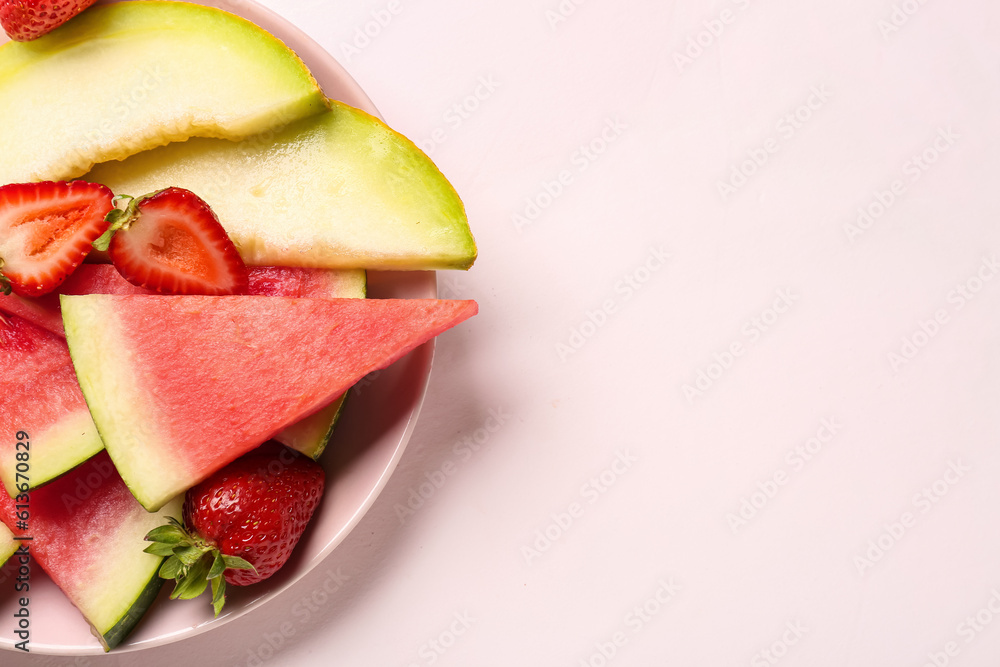 Plate with pieces of fresh watermelon and different berries on light background