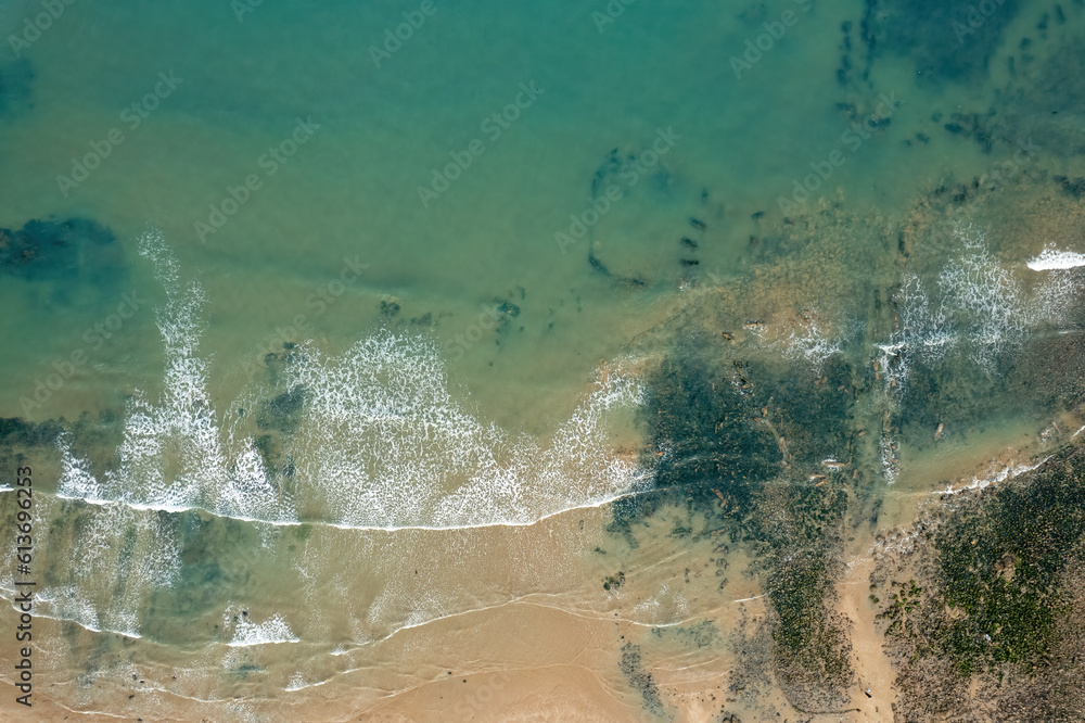 Aerial view of the beach, with green water and warm beaches