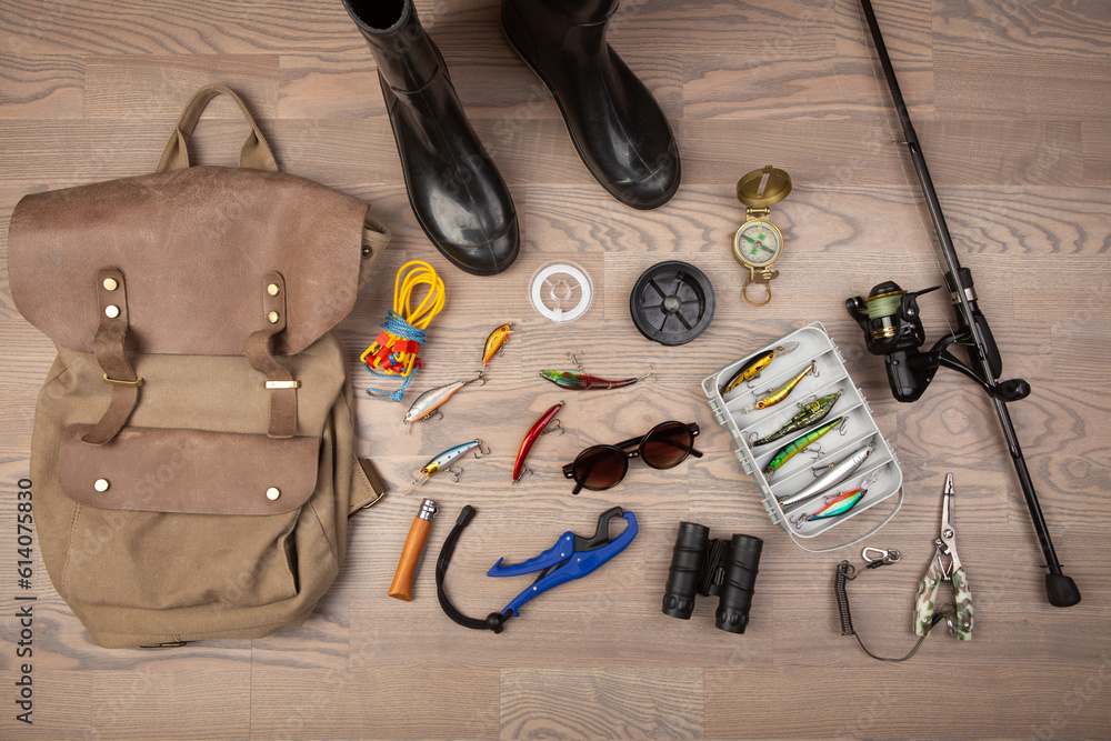 Fishing rod, tackles and other stuff for recreation activity on the wooden desk. Fishing season conc