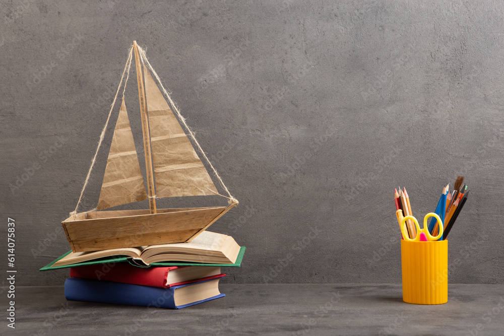 Education is a journey concept, toy boat and books on the table, inspiration for a writing a fairy t