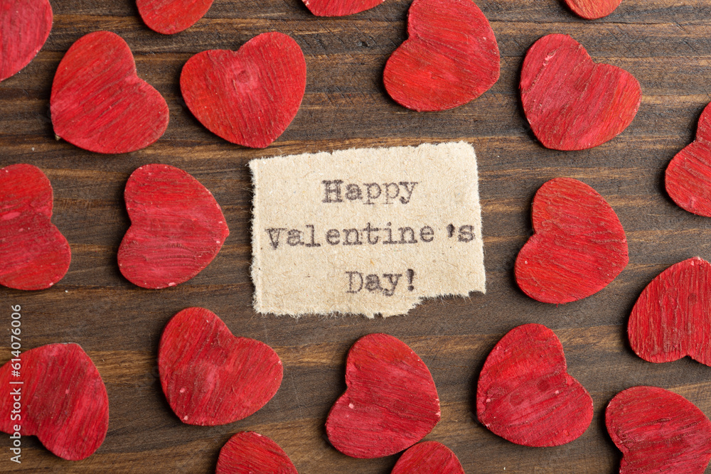 Happy Valentine`s day - typed text. Valentines Day greetings concept. Little red wooden hearts close