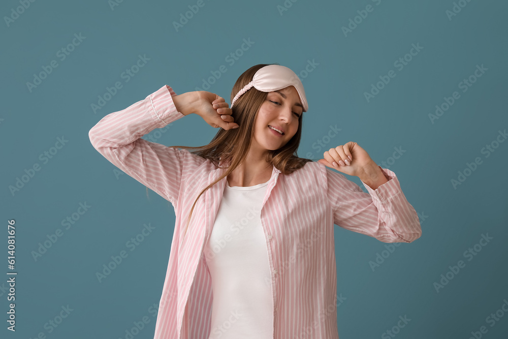 Young woman with sleeping mask on blue background