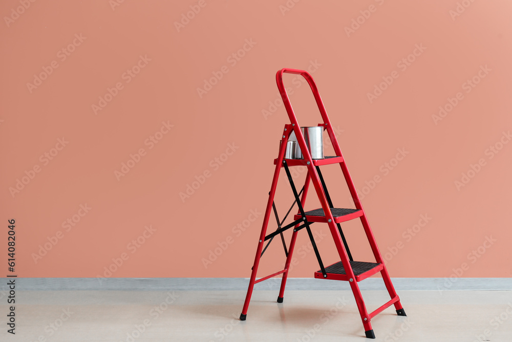 Maintenance ladder with cans of paint near color wall