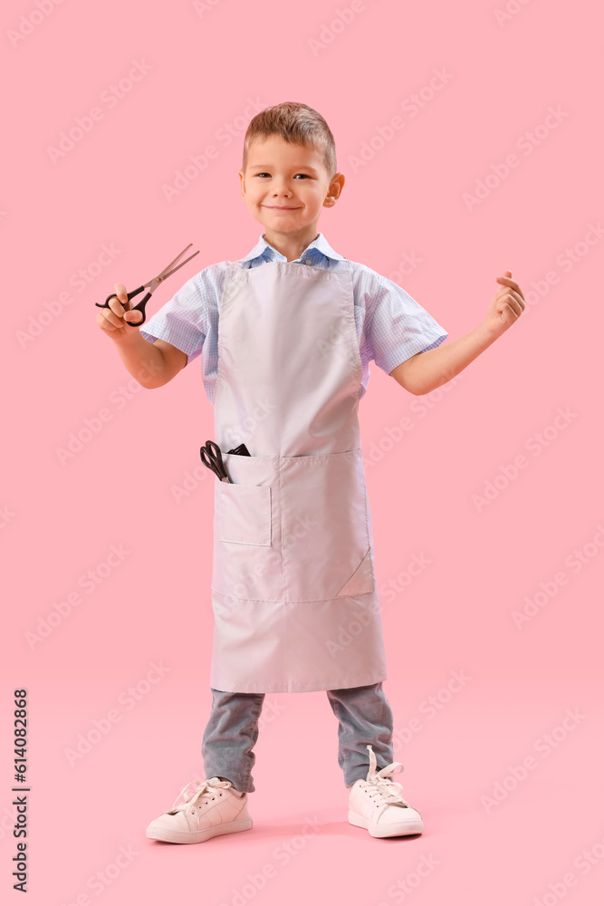 Funny little hairdresser pointing at scissors on pink background