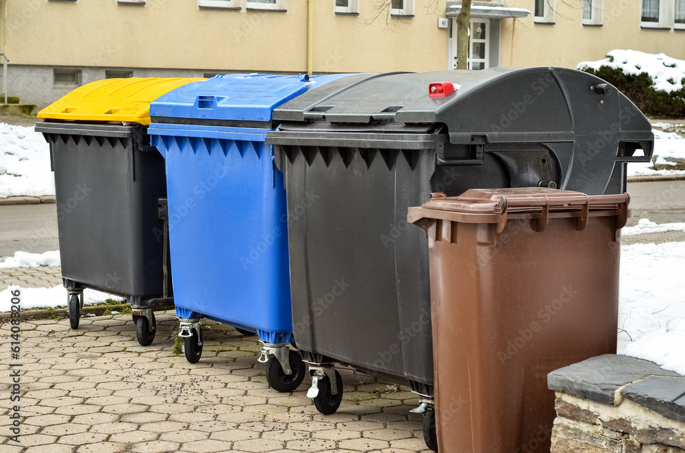 View of garbage containers in city on winter day