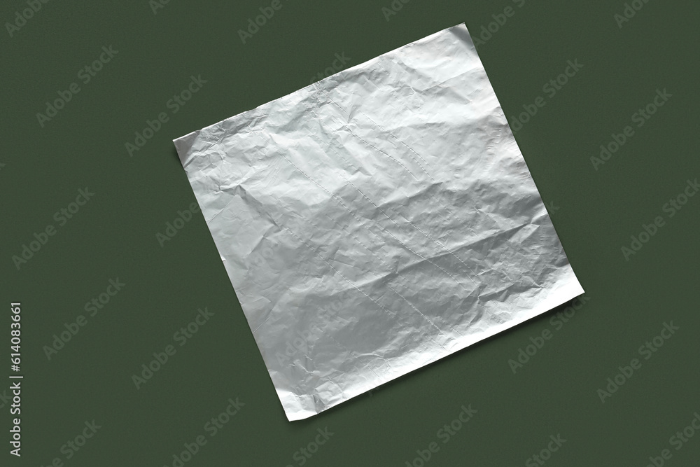 Sheet of aluminium foil on green background