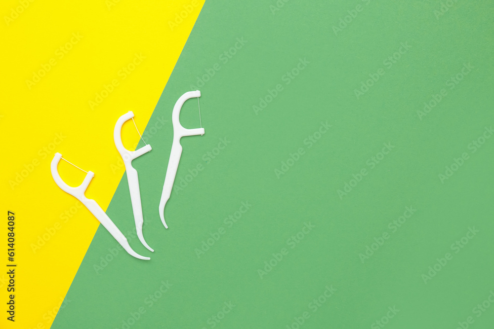 Floss toothpicks on yellow and green background