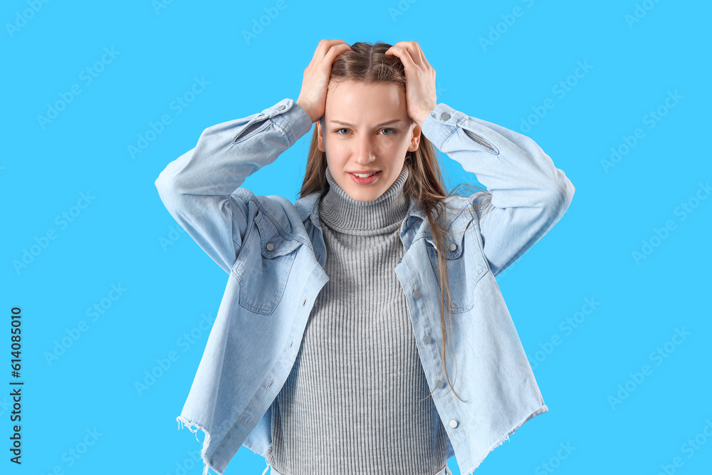 Stressed female student on blue background