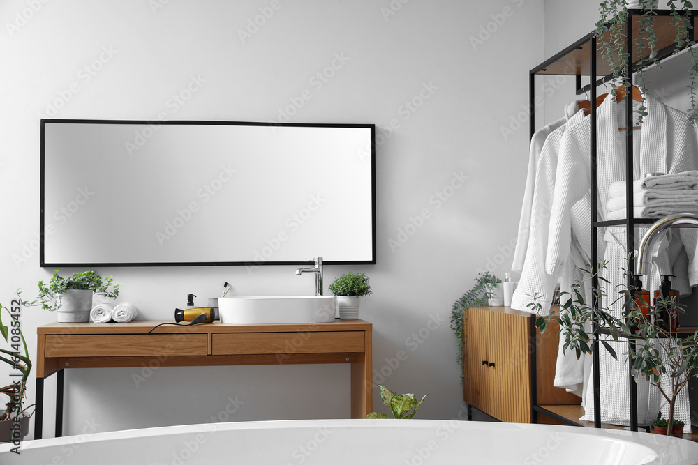 Interior of light bathroom with shelving unit, mirror and sink