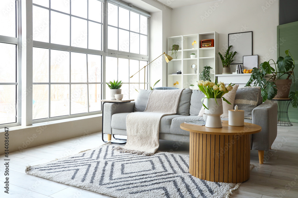 Interior of bright living room with grey sofa and coffee table