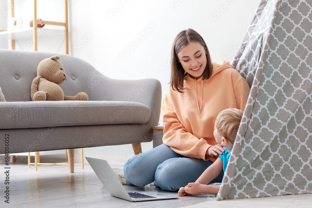 Nanny with little boy watching cartoons at home