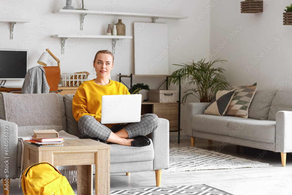 Thoughtful female student studying online with laptop at home