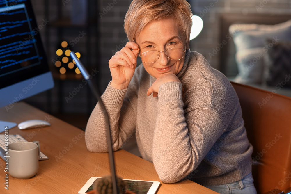 Mature female programmer working in office at night