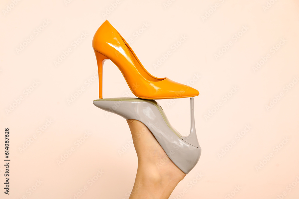 Female leg with stylish high heeled shoes on light background, closeup