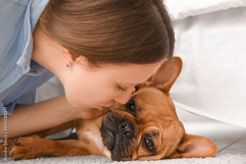 Young woman with cute French bulldog in bedroom, closeup