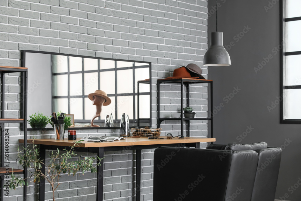 Interior of beauty salon with comfortable armchair, table and mirror