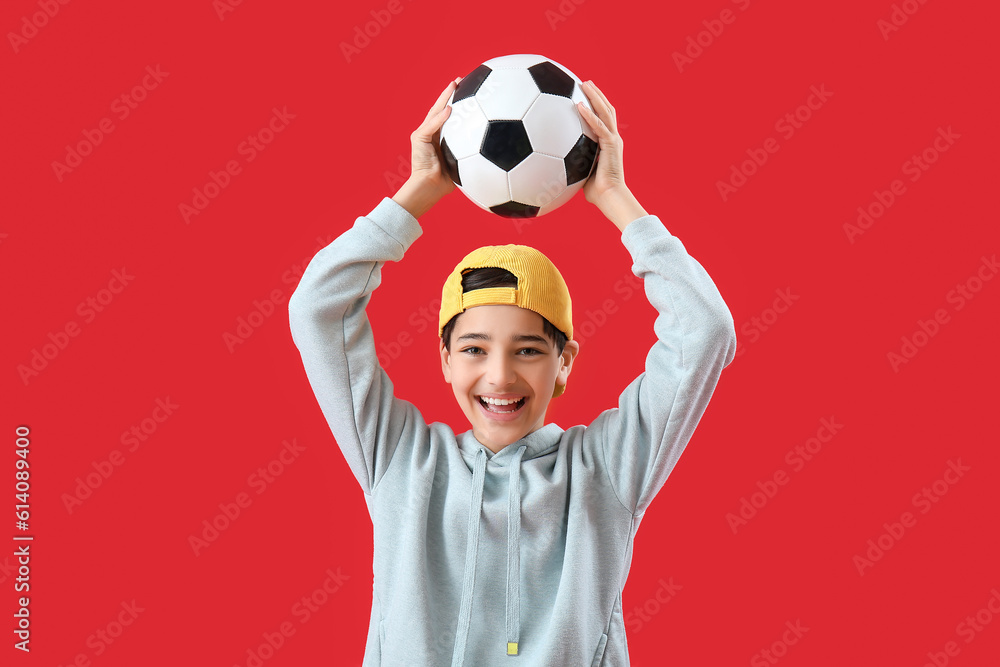 Little boy with soccer ball on red background