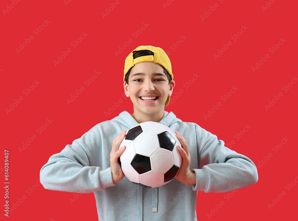 Little boy with soccer ball on red background