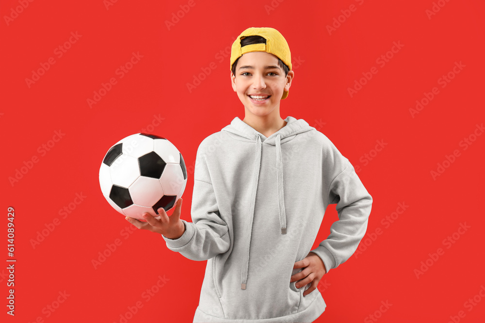 Little boy with soccer ball on red background