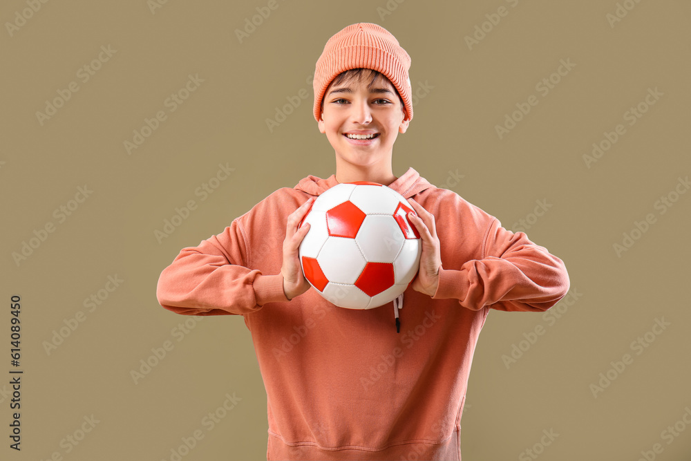 Little boy with soccer ball on color background