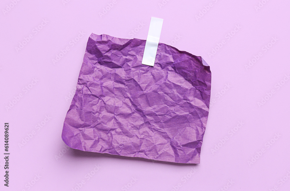 Crumpled paper sheet with adhesive tape on lilac background