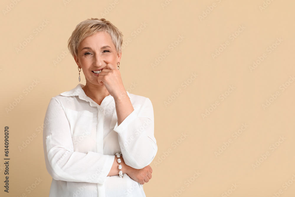 Mature blonde woman in white shirt on beige background